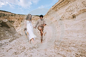 happy couple holding hands and kicking sand