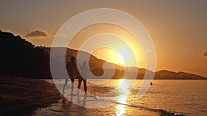 Happy couple holding hands running in tropical beach at amazing sunset in slow motion. 1920x1080