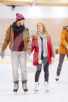 Happy couple holding hands on skating rink