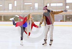 Happy couple holding hands on skating rink