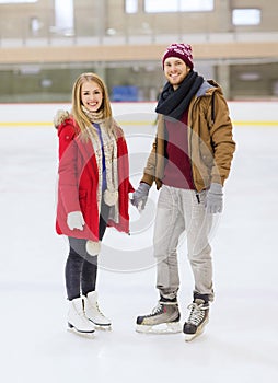 Happy couple holding hands on skating rink