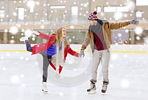 Happy couple holding hands on skating rink