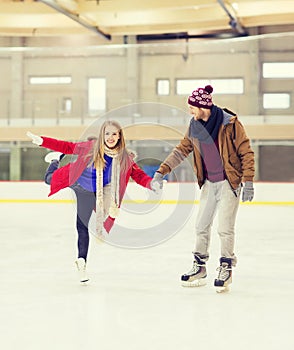 Happy couple holding hands on skating rink