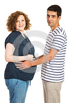 Happy couple holding hands on tummy