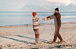 Happy couple holding hands walking on beach man and woman young family