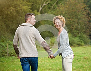 Happy couple holding hands and walking outdoors