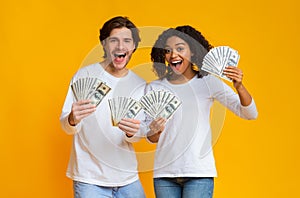 Happy couple holding lot of dollar cash in hands, rejoicing success