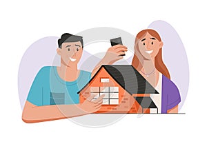Happy couple holding model of building, buying new house