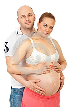 Happy couple holding pregnant belly