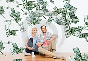 Happy couple at home over dollar money falling