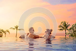 Happy couple on honeymoon in luxury hotel pool