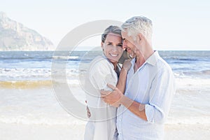 Happy couple hugging on the beach woman looking at camera