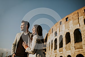 Happy couple hugging in front of Colosseum in Rome, Italy