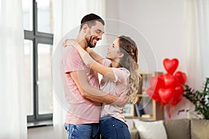 Happy couple hugging at home on valentines day