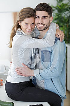 Happy couple hugging in kitchen