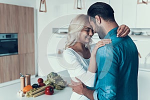 Happy couple hugging in kitchen. Romantic relationship.
