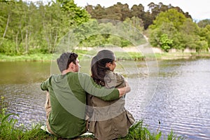 Happy couple hugging on lake or river bank