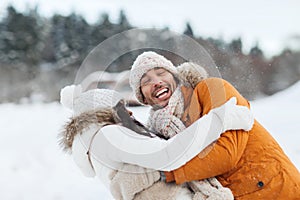 Happy couple hugging and laughing in winter