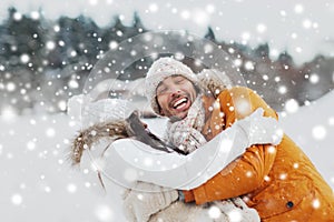 Happy couple hugging and laughing in winter