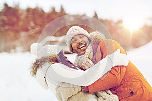 Happy couple hugging and laughing in winter