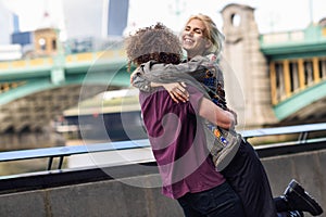 Happy couple hugging near the Southwark bridge over River Thames, London