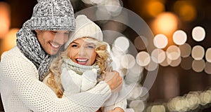 Happy couple hugging over christmas lights