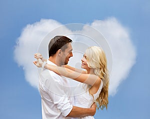 Happy couple hugging over heart shaped cloud