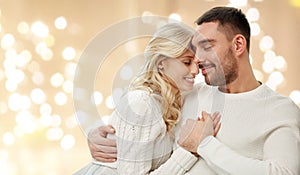 Happy couple hugging over lights on background