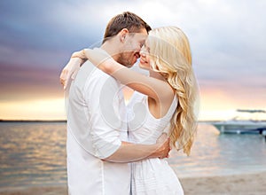 Happy couple hugging over sunset at summer beach