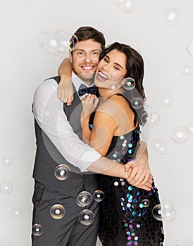 Happy couple hugging in soap bubbles at party