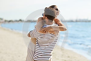 happy couple hugging on summer beach