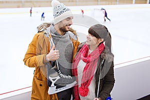 Happy couple with ice-skates on skating rink