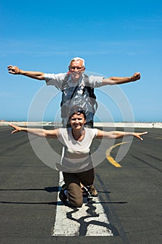 Happy couple imitating airplane at the airport