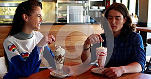 Happy couple interacting with each other while having milkshake