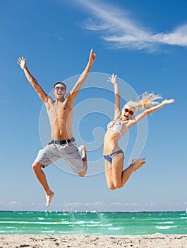 Happy couple jumping on the beach