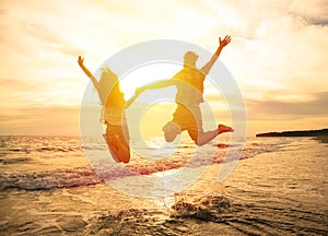 happy couple jumping on beach