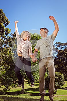 Happy couple jumping in the park