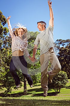 Happy couple jumping in the park