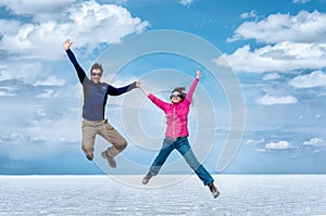 happy couple jumping in Uyuni Salt Flats , Bolivia, South America