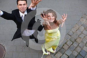 Happy couple jumps up with rose hands