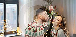 Happy couple kissing under mistletoe on christmas