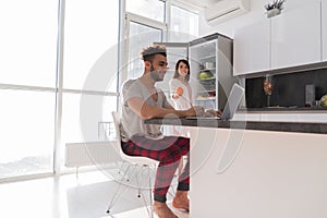 Happy Couple On Kitchen Using Laptop Computer Modern Apartment With Panoramic Window