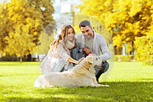 Happy couple with labrador dog in autumn city park