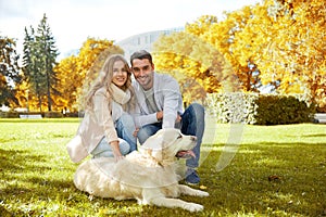 Happy couple with labrador dog walking in city