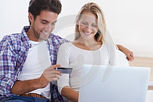 Happy couple, laptop and credit card for ecommerce, payment or banking together in relax at home. Man and woman smile