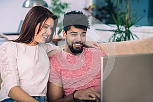 Happy couple with laptop spending time together