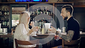 A happy couple laughing while communicating with each other, a young woman with blond hair tells a funny story, a