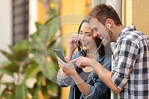 Happy couple laughing listening to music online