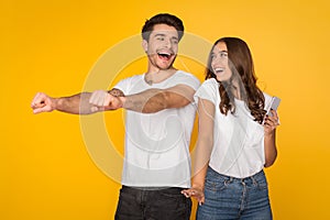 Happy couple listening music by earphones and dancing