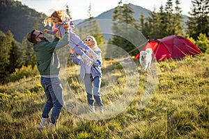 Happy couple with little girl have fun while travel in the mountains